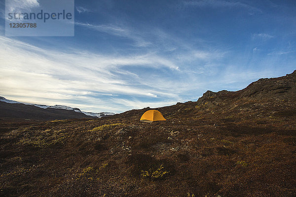 Grönland bietet einige der spektakulärsten Landschaften  die es zu erkunden und zu campen gibt. Hier wird ein einsames Zelt in den herbstlichen Hügeln der Disko-Insel aufgestellt.