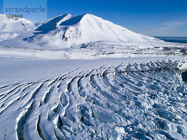 Schöne arktische Landschaft mit Gletscherspalten und verschneiten Bergen im Hintergrund  Krossfjorden  Spitzbergen  Svalbard und Jan Mayen  Norwegen