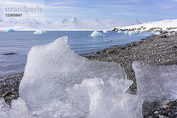 Nahaufnahme des schmelzenden Eises am felsigen Küstenstrand des Eismeeres  Svalbard