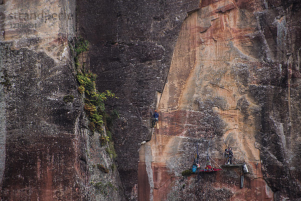 Entfernte Ansicht eines abenteuerlustigen Kletterers  der eine schwierige Klippe erklimmt  Liming  Provinz Yunnan  China