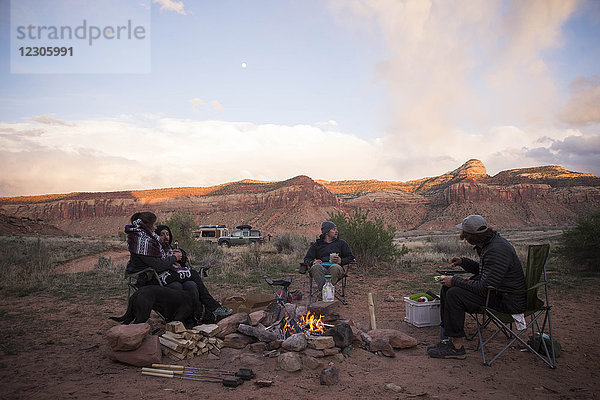 Gruppe von drei Männern und einer Frau sitzt am Lagerfeuer in Moab  Utah  USA