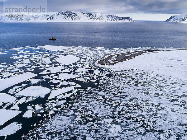Luftaufnahme des Arktischen Ozeans mit Packeis und Fischerboot im Hintergrund  Danskoya  Spitzbergen  Svalbard und Jan Mayen  Norwegen