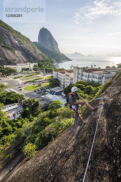 Abenteuerlustiger Mann beim Klettern am Berg Babilonia (Morro da Babilonia) in der Nähe des Zuckerhuts (Pao de Acucar) in Urca  Rio de Janeiro  Brasilien