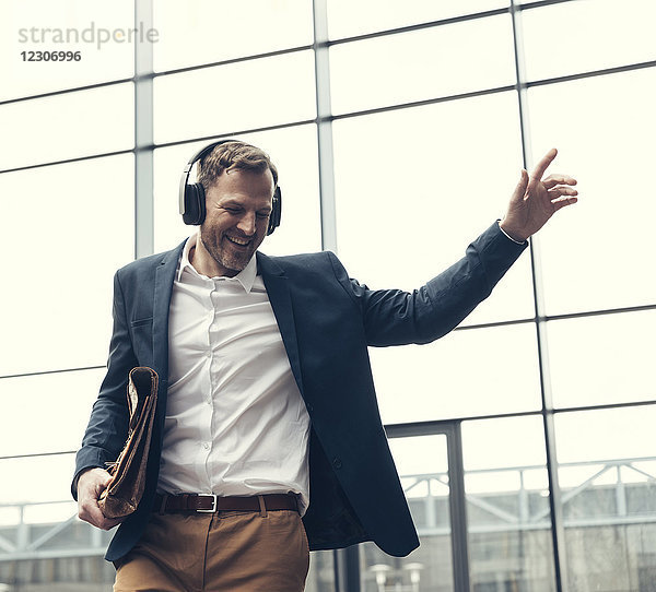 Glücklicher Geschäftsmann beim Musikhören mit Kopfhörern