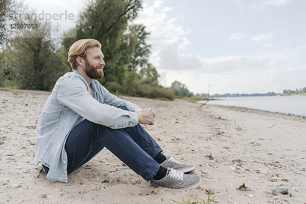 Deutschland  Düsseldorf  entspannter Mann am Strand mit Blick auf den Strand