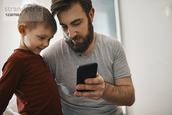 Vater erklärt kleinen Sohn Smartphone