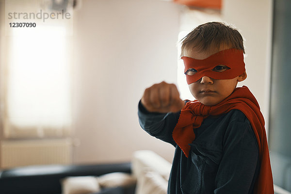 Porträt des kleinen Jungen als Superheld verkleidet zu Hause