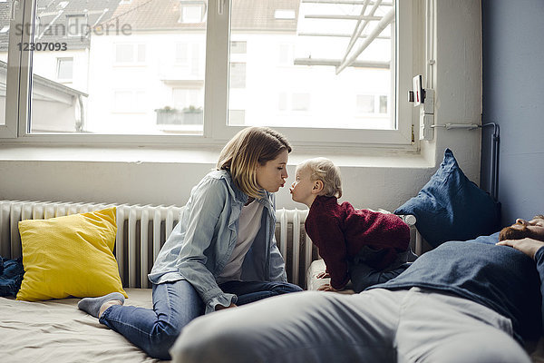 Familie entspannt zu Hause auf dem Sofa  Mutter küsst Baby-Sohn