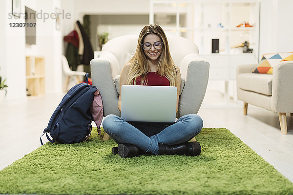 Lässige junge Frau mit Laptop im Coworking Space