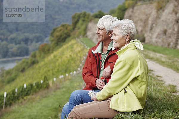 Deutschland  Rheingau  Wandern Seniorenpaar beim Ausruhen
