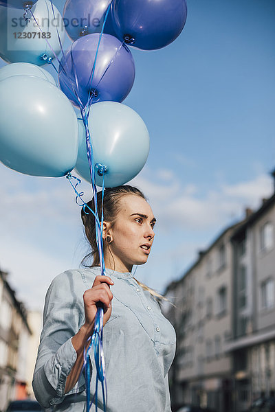 Porträt einer Frau mit blauen Luftballons