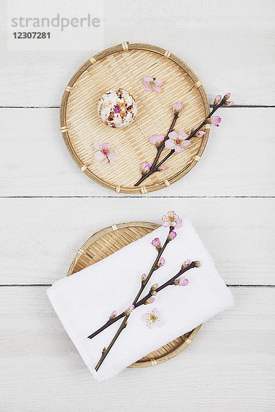 Kirschblüten-Seifenkugel und Handtuch auf Bambusschalen