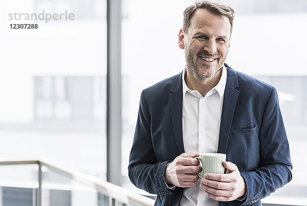 Porträt eines lächelnden Geschäftsmannes bei einer Kaffeepause