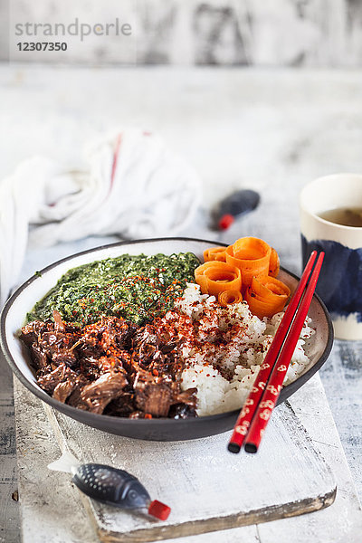 Vegane Teriyaki-Schale mit gezogenem Teriyaki-Rindfleisch aus Jackfrucht  Spinat  Reis und Karotten