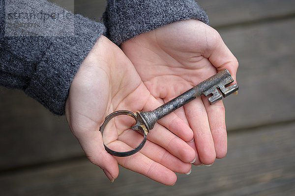 Hände halten einen alten Schlüssel  Nahaufnahme