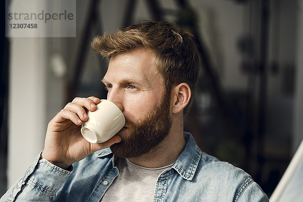 Mann entspannt sich zu Hause  trinkt Kaffee