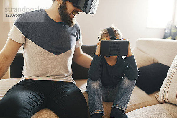 Vater und kleiner Sohn mit Virtual-Reality-Brille zu Hause