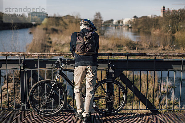 Radfahrer auf der Brücke stehend