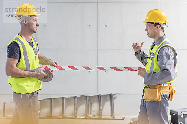 Bauarbeiter mit Klebeband auf der Baustelle