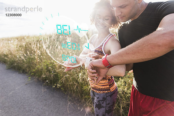 Sportliches junges Paar mit einer Pause bei der Überprüfung von Daten aus smartwatch