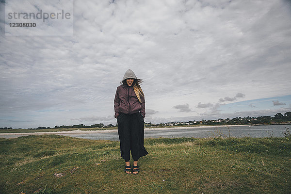 Frankreich  Bretagne  Landeda  Dunes de Sainte-Marguerite  junge Frau an der Küste stehend