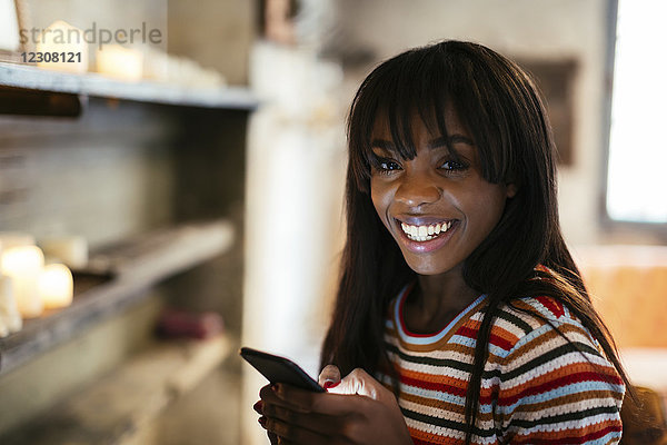 Porträt einer glücklichen jungen Frau mit Handy