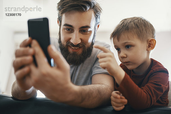 Portrait von Vater und Sohn mit Smartphone