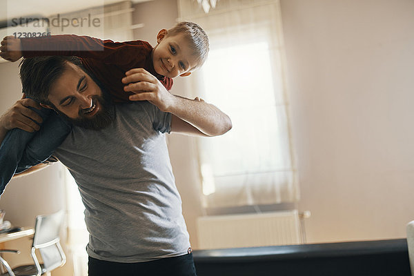 Glücklicher Vater und kleiner Sohn beim gemeinsamen Spielen zu Hause
