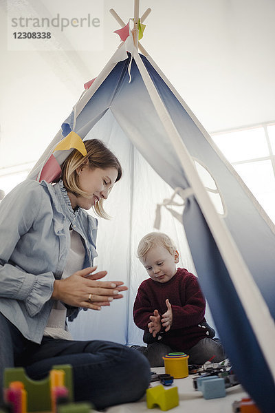 Mutter spielt mit ihrem Sohn in einem Zelt zu Hause