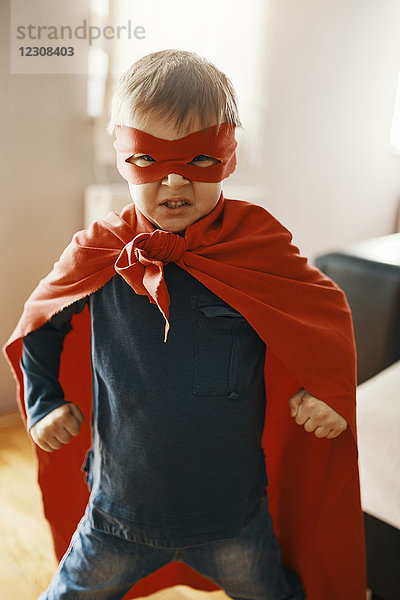 Porträt des kleinen Jungen als Superheld verkleidet zu Hause