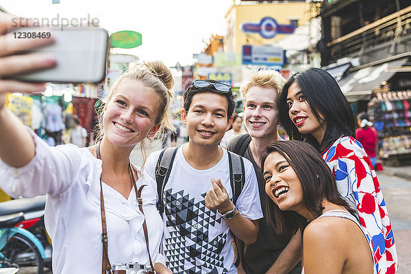 Thailand  Bangkok  Khao San Road  Gruppe von Freunden  die Selfie mit Smartphone nehmen