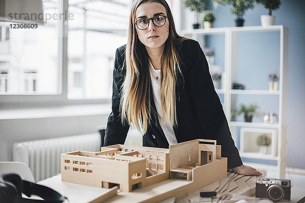 Portrait des Architekten mit Architekturmodell im Büro