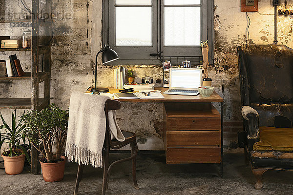 Alter Schreibtisch mit Laptop im Loft