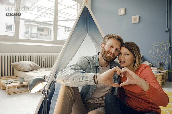 Glückliches Paar zu Hause Camping in einem Zelt im Wohnzimmer