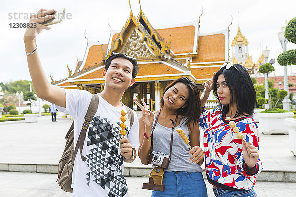 Thailand  Bangkok  drei Freunde mit Straßenessen  die Selfie nehmen