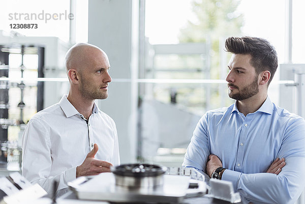 Zwei Männer diskutieren über das Produkt in Gesellschaft