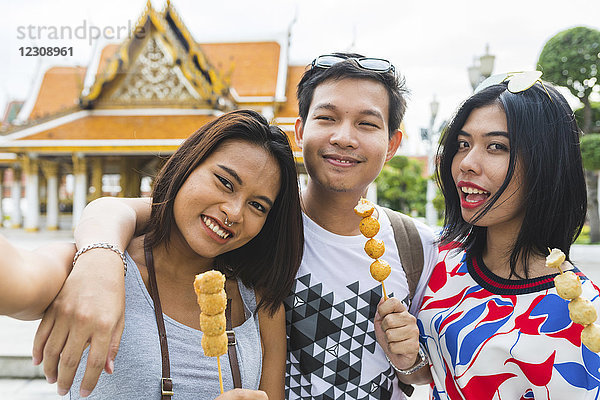 Thailand  Bangkok  Porträt von Freunden mit Straßenessen und Selbstbedienung