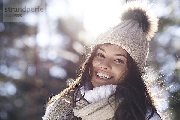 Porträt einer glücklichen jungen Frau im Winterwald