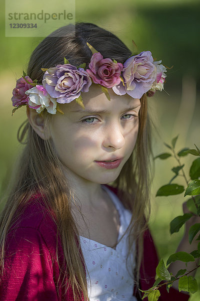 Porträt eines träumenden kleinen Mädchens mit Blumen