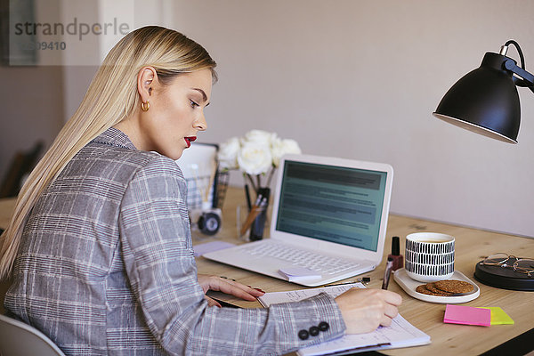 Junge Geschäftsfrau im Büro mit Laptop