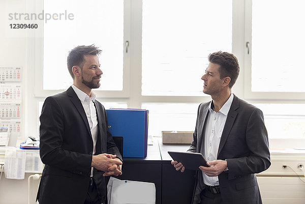 Zwei Geschäftsleute im Amt  die Lösungen diskutieren  mit dem digitalen Tablett