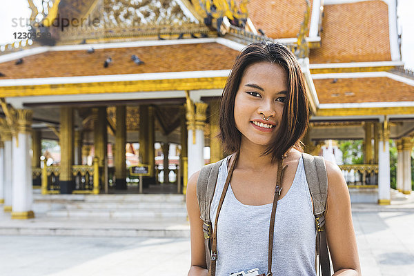 Thailand  Bangkok  Portrait eines lächelnden Touristen mit Kamera