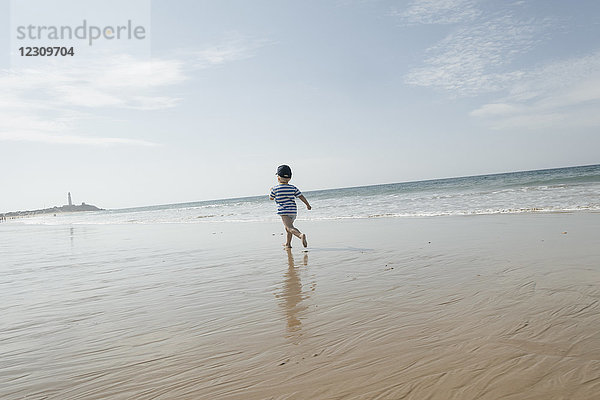 Spanien  Kap Trafalgar  Junge  der am Strand rennt