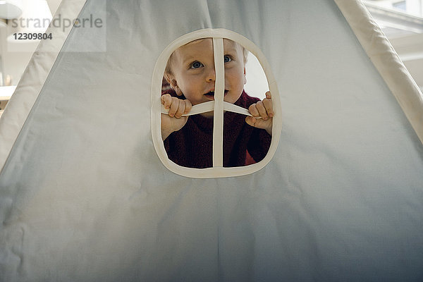 Kleiner Junge spielt im Zelt  schaut durchs Fenster  lacht.