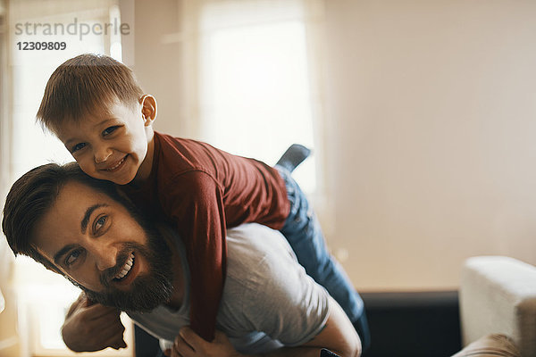 Porträt eines glücklichen Vaters und eines kleinen Sohnes  die zusammen zu Hause spielen.