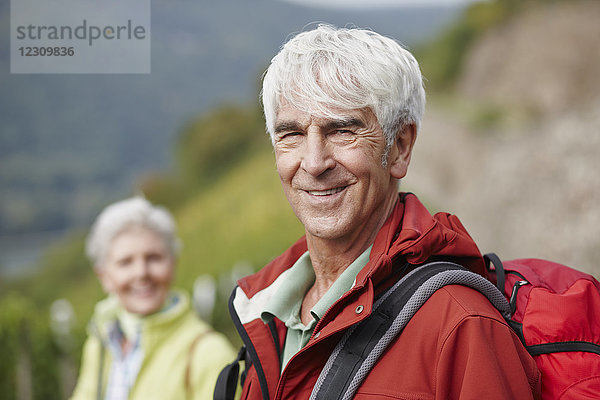 Porträt eines lächelnden Senioren mit Rucksack