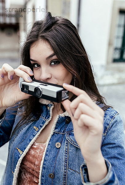 Porträt einer brünetten Frau mit einer alten Kamera in einer Stadt