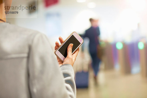 Geschäftsfrau am Flughafen  Smartphone in der Hand  Rückansicht  Mittelteil