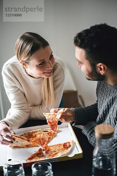 Paare essen Pizza zum Mitnehmen