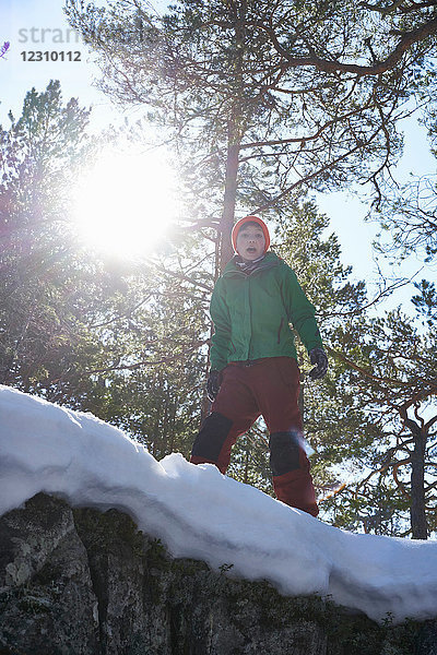 Porträt eines Jungen  stehend in schneebedeckter  ländlicher Landschaft  Blick aus niedrigem Winkel
